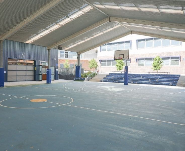 School basketball court with basketball hoop and stairs in background