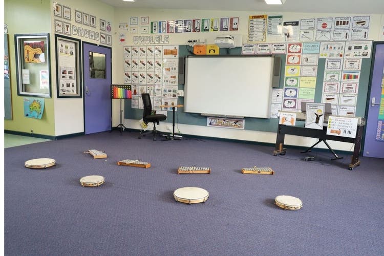 Music classroom with xylophones and tambourines laid out on carpet