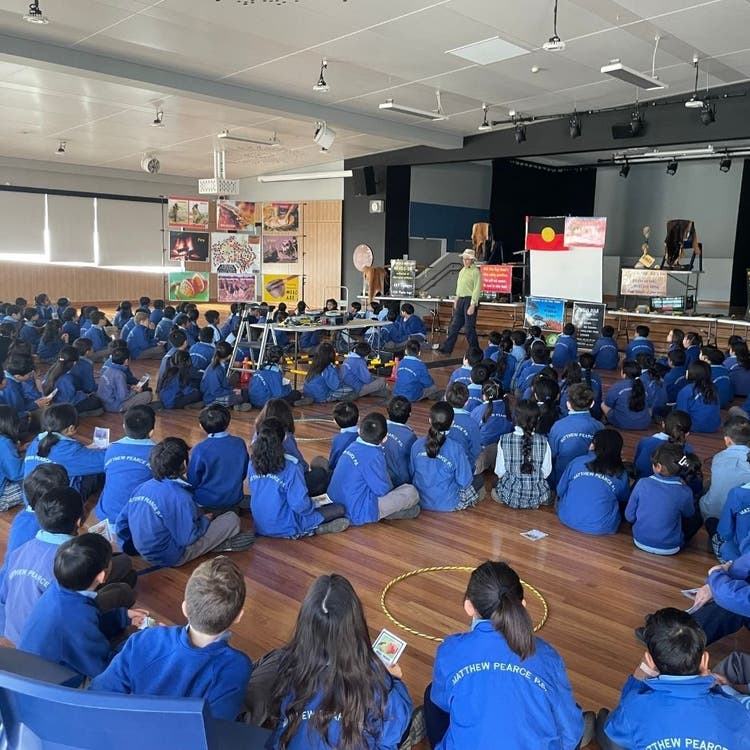 Children sitting in school hall listening to presentation