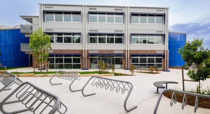 Bike racks on concrete courtyard in front of school building