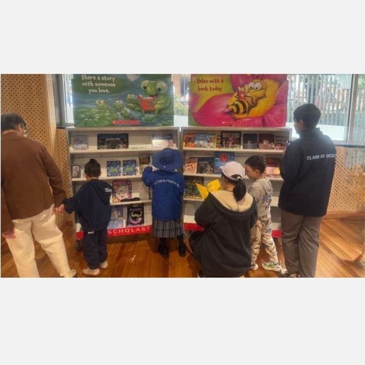 Parents and children browsing shelf of books at a book fair